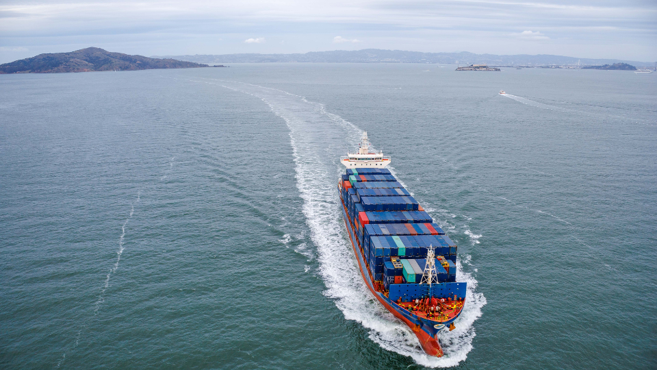 A container ship in the ocean carrying product-filled containers.