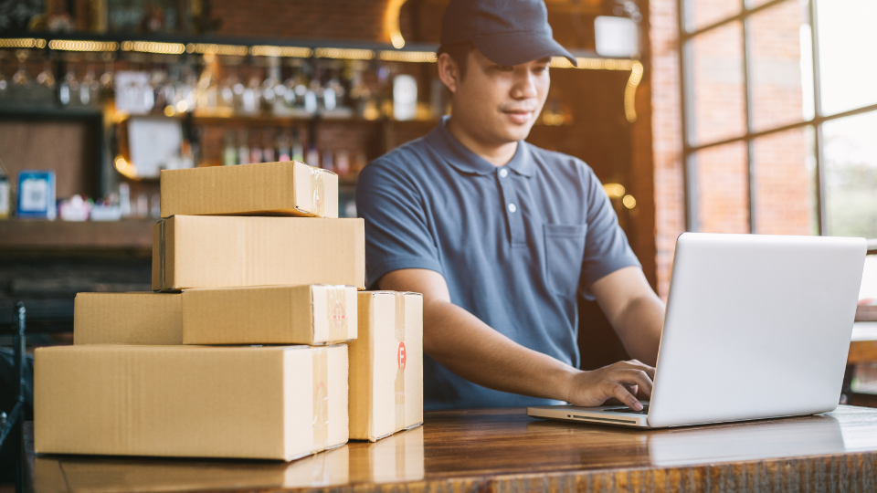 A person working on a laptop in front of boxes