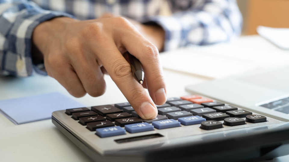 A person using a calculator on a desk