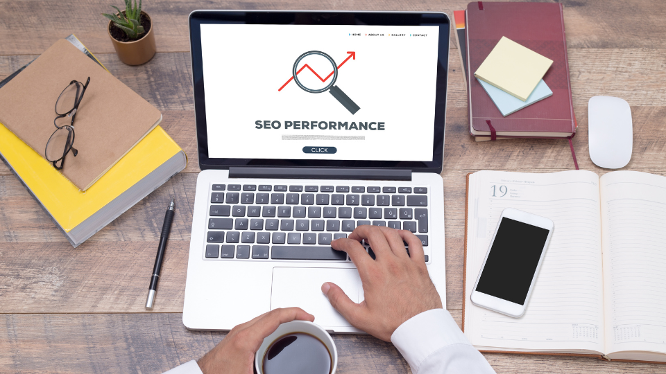 A laptop open with an SEO performance tool displayed on the screen