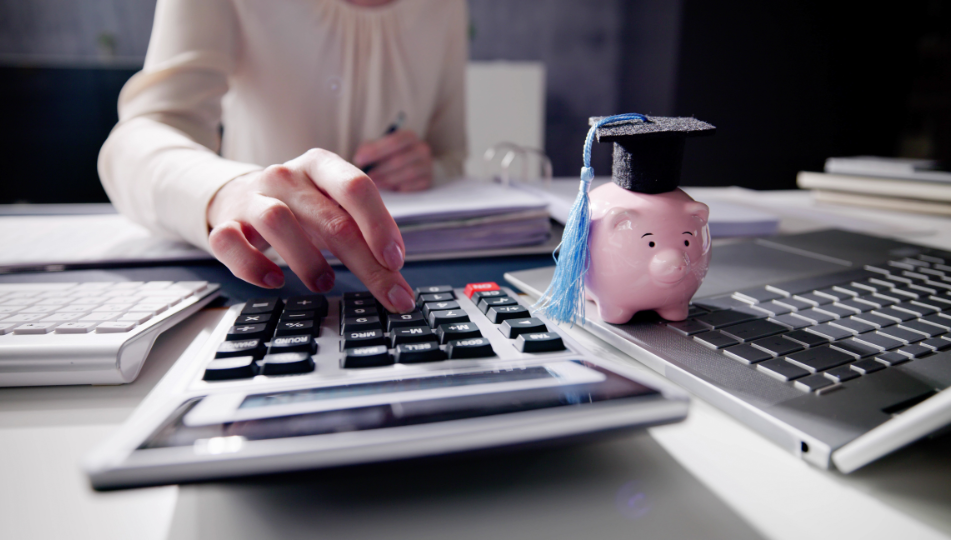 A business owner sitting at a desk, using a calculator to calculate Amazon FBA fees