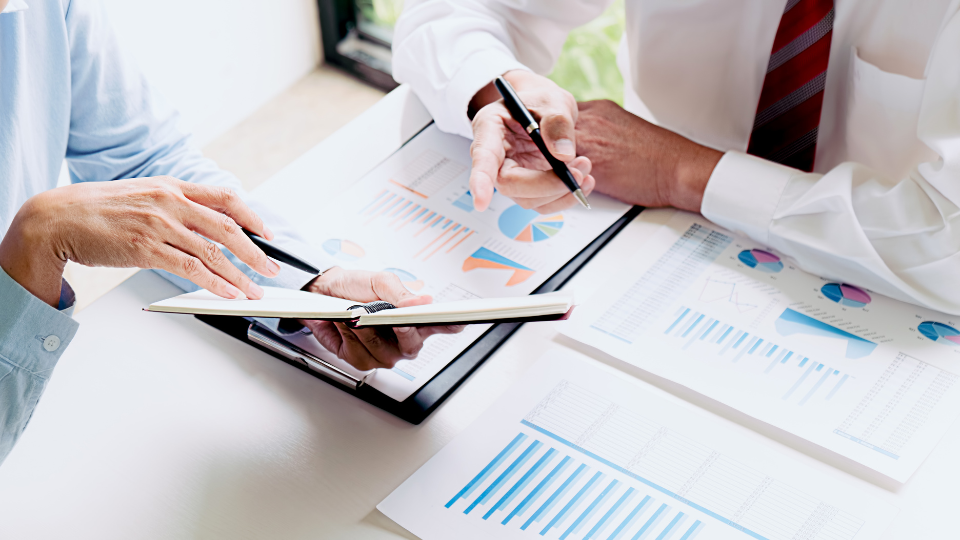 Two business people sitting at a table working on a competitive pricing strategy